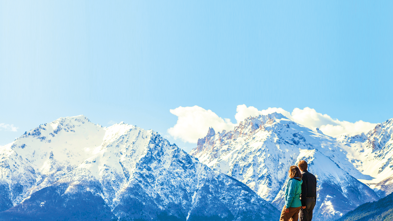 a distância, casal observa as montanhas em Bariloche