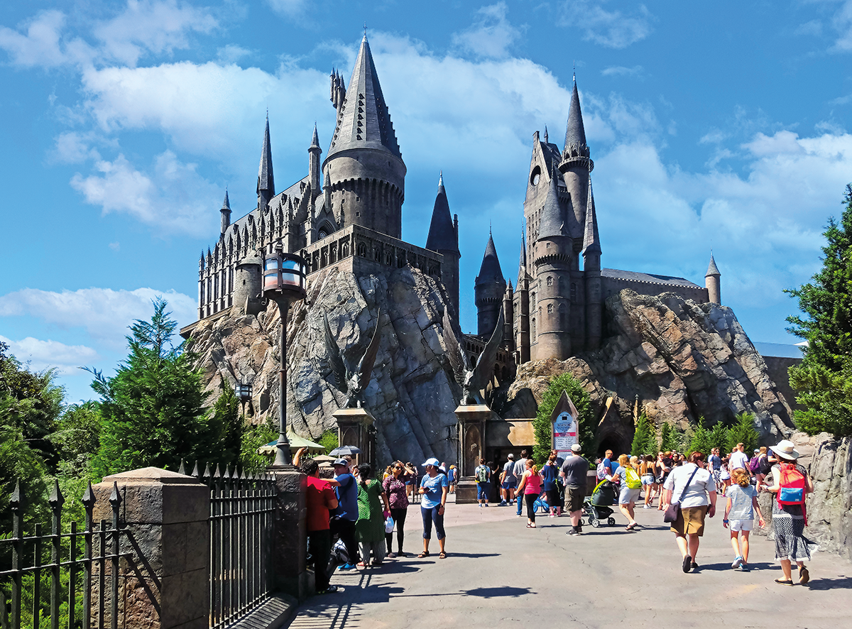 castelo de hogwarts na disney, abaixo turistas caminhando