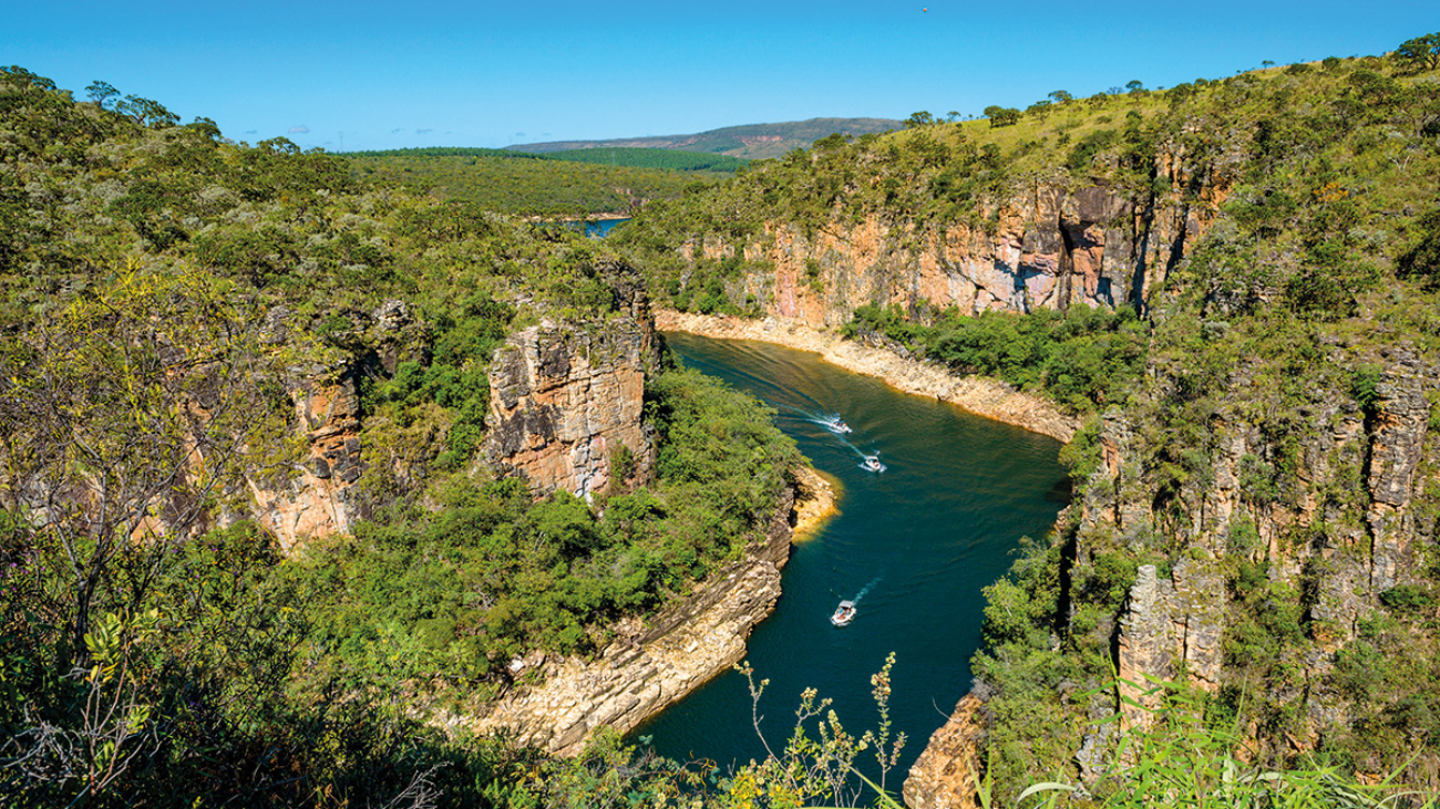 Um lugar com vegetação e um imenso lago no meio
