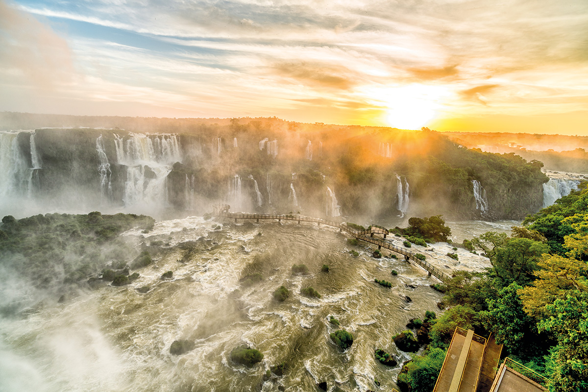 Imagem das quedas dágua das Cataratas do Iguáçu com um forte sol ao fundo