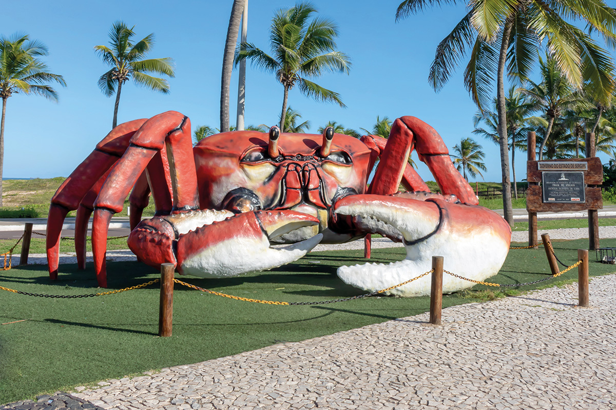 Escultura de um carangueijo gigante na beira da praia.