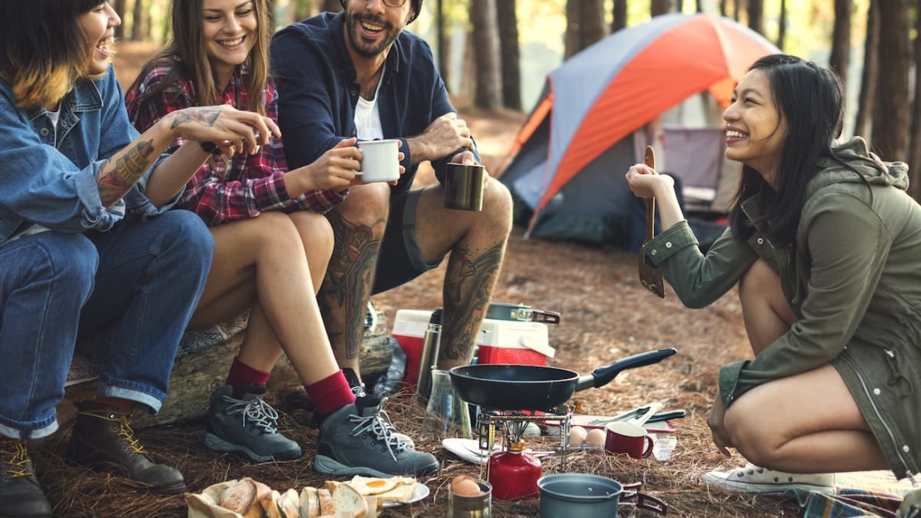 Imagem com amigos reunidos em um camping a luz do dia