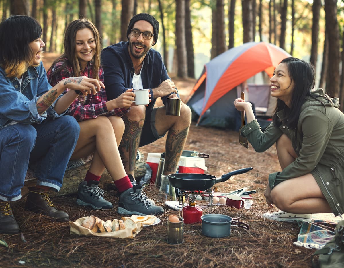 Imagem com amigos reunidos em um camping a luz do dia