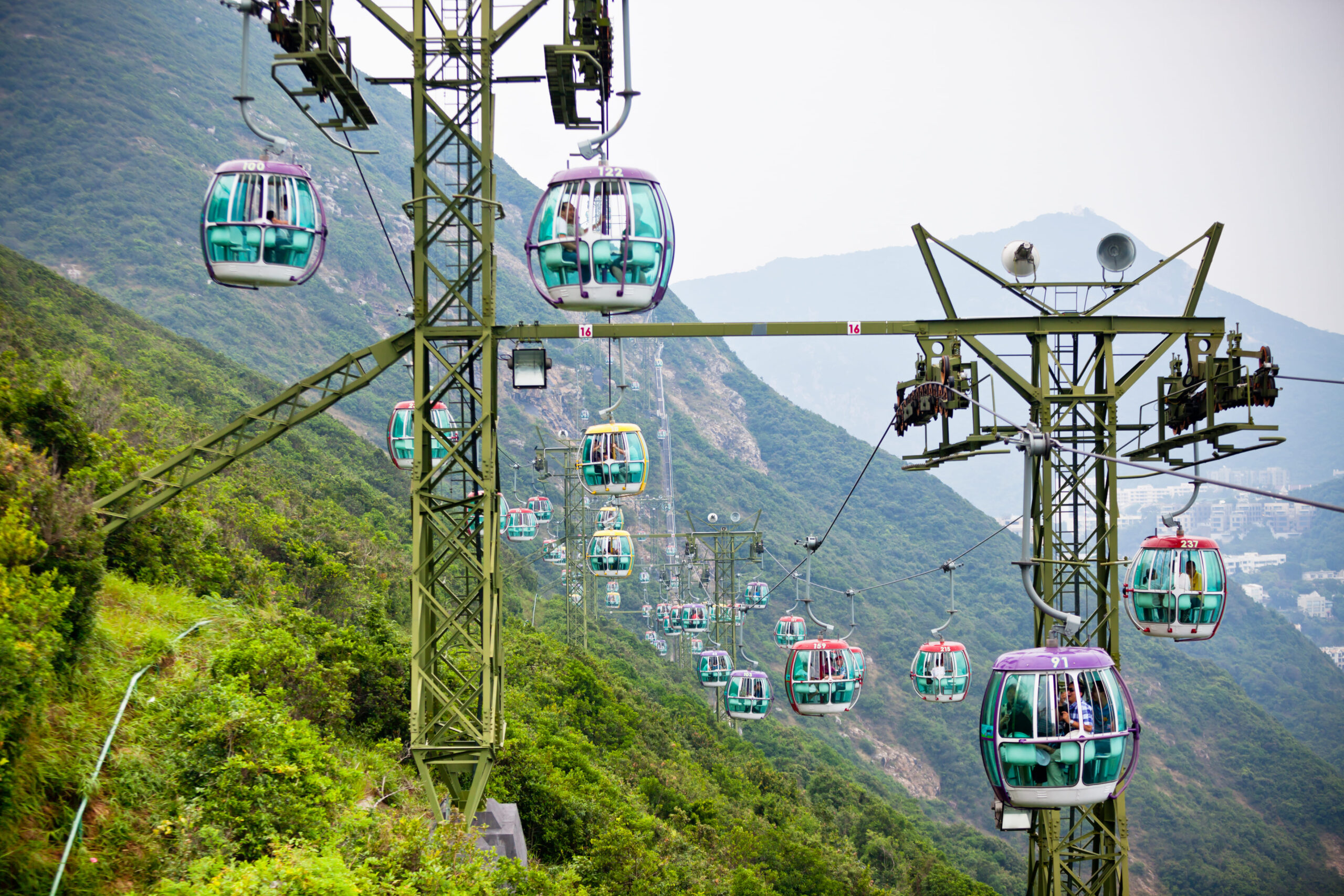 Teleférico transportando pessoas acima de árvores tropicais de Hong Kong