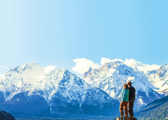 a distância, casal observa as montanhas em Bariloche