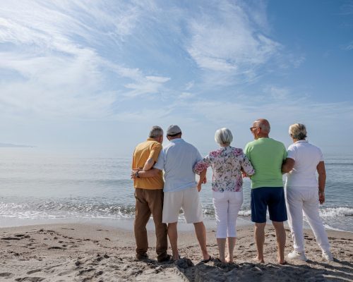 Group,Of,5,Seniors,At,The,Beach,Standing,Together,Looking