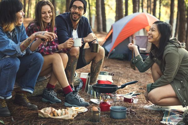 Imagem com amigos reunidos em um camping a luz do dia